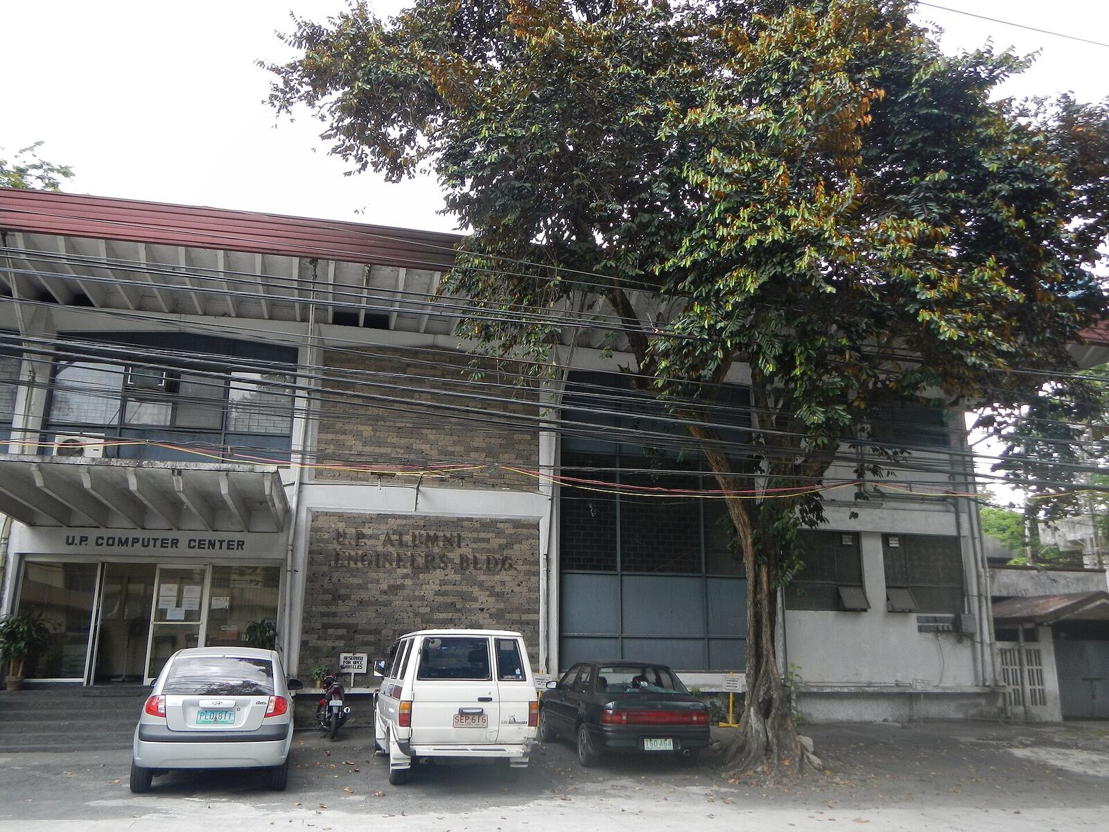 University of the Philippines Computer Center | Life of Internet The University of the Philippines Computer Center and Alumni Engineers Building with parked vehicles on campus, showcasing.